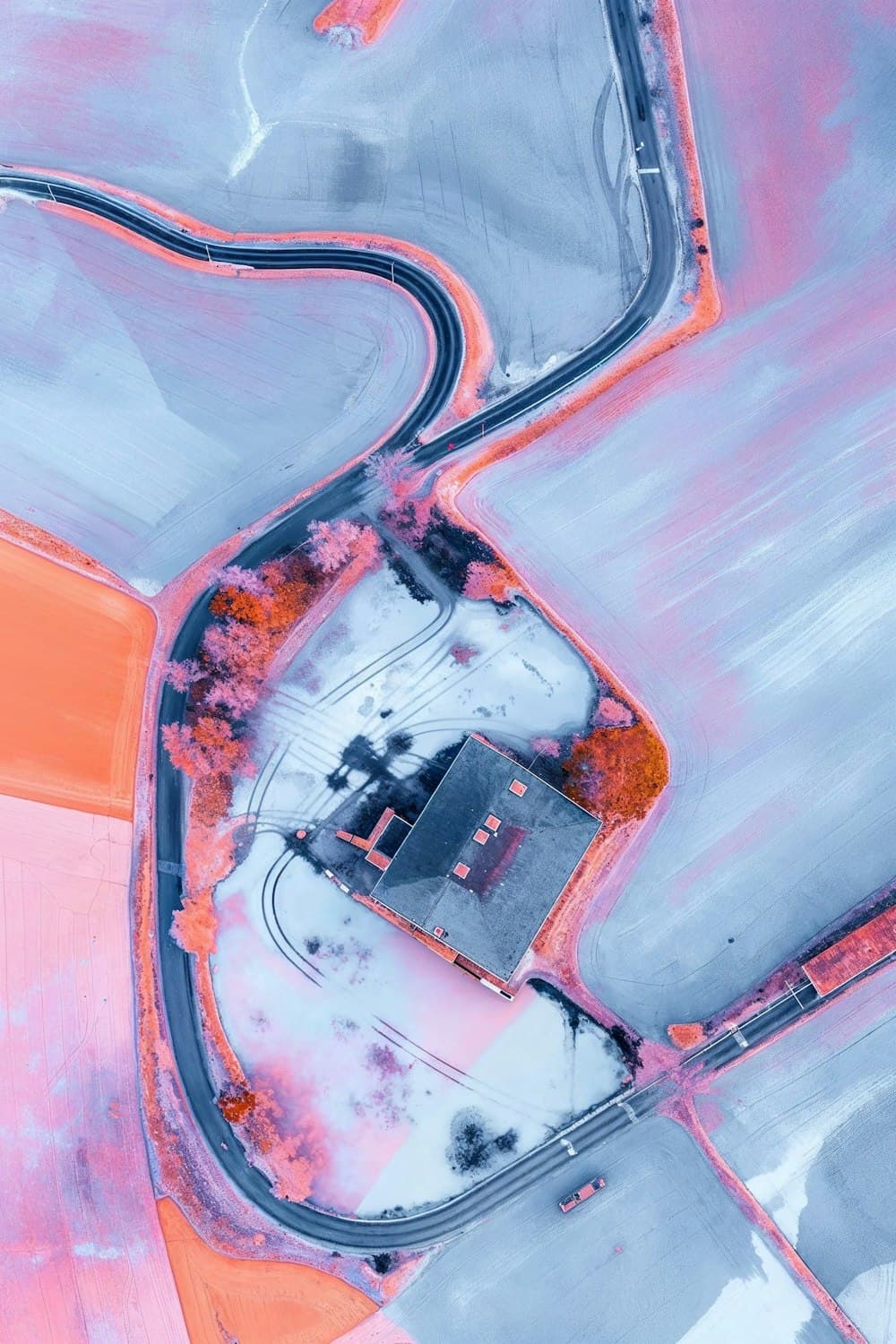Aerial view of a road winding between fields